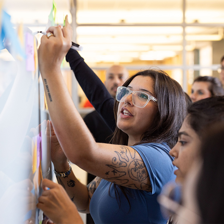 A Student writes on a whiteboard